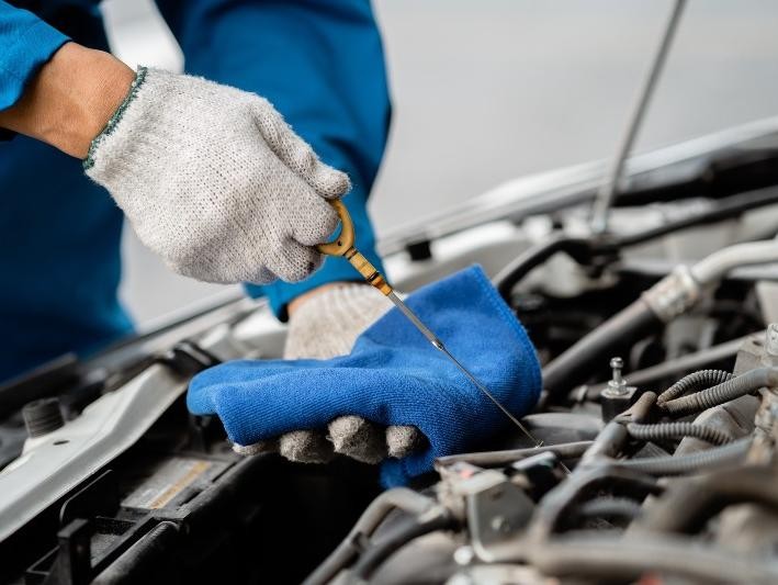 Mechanic checking oil at Gerry Lane Cadillac 