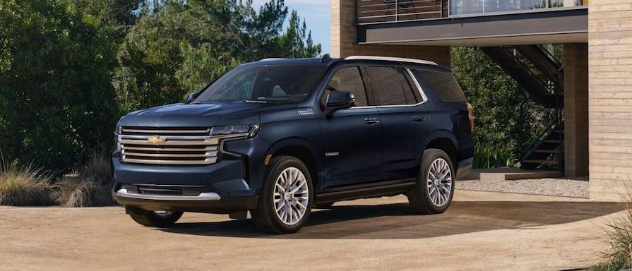 Blue 2023 Chevy Tahoe parked outside of a residential home 