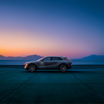 The new electric Cadillac Lyriq SUV in front of a sunset.