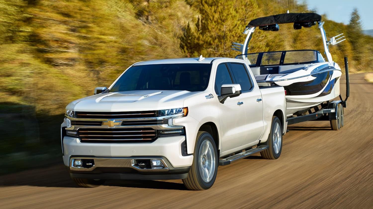 White Chevy Silverado 1500 Towing A Boat