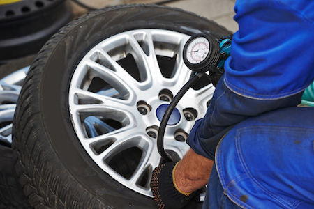 Mechanic adding air to tire