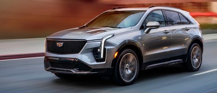Cadillac 2024 XT4 Sport AWD Argent Silver with Sky Cool Gray and Jet Black with Santorini Blue Accents interior; 20" Dynamic multi-spoke alloy wheels with Diamond Cut / Dark Android finish  3/4 drivers side front view of vehicle driving