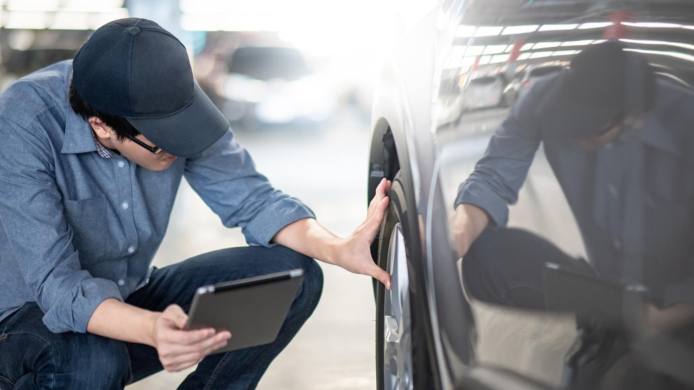 Man Inspecting Vehicle