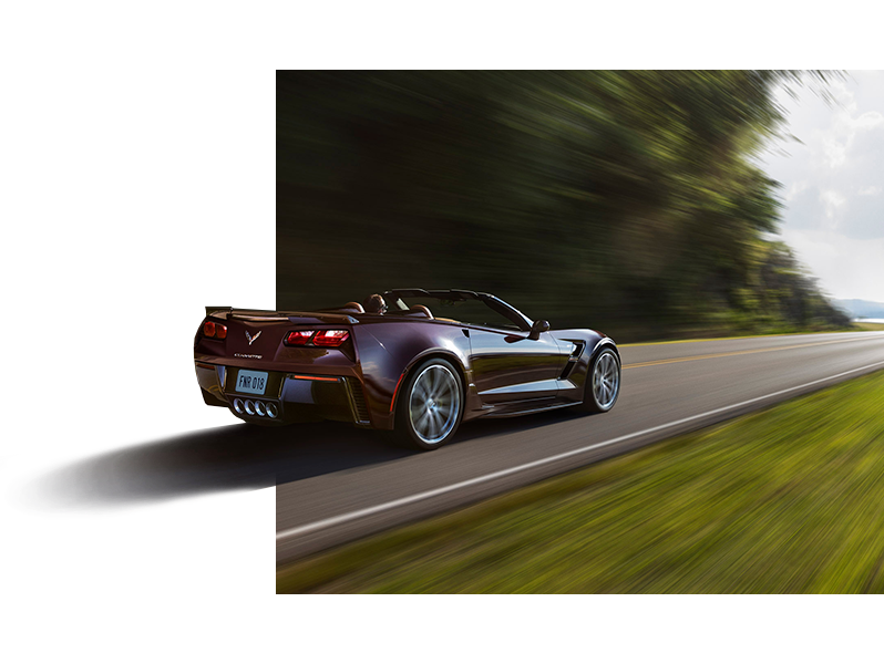 Burgundy Corvette driving on a road