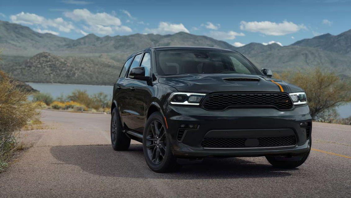 2023 Dodge Durango driving on a country road with a lake in the background