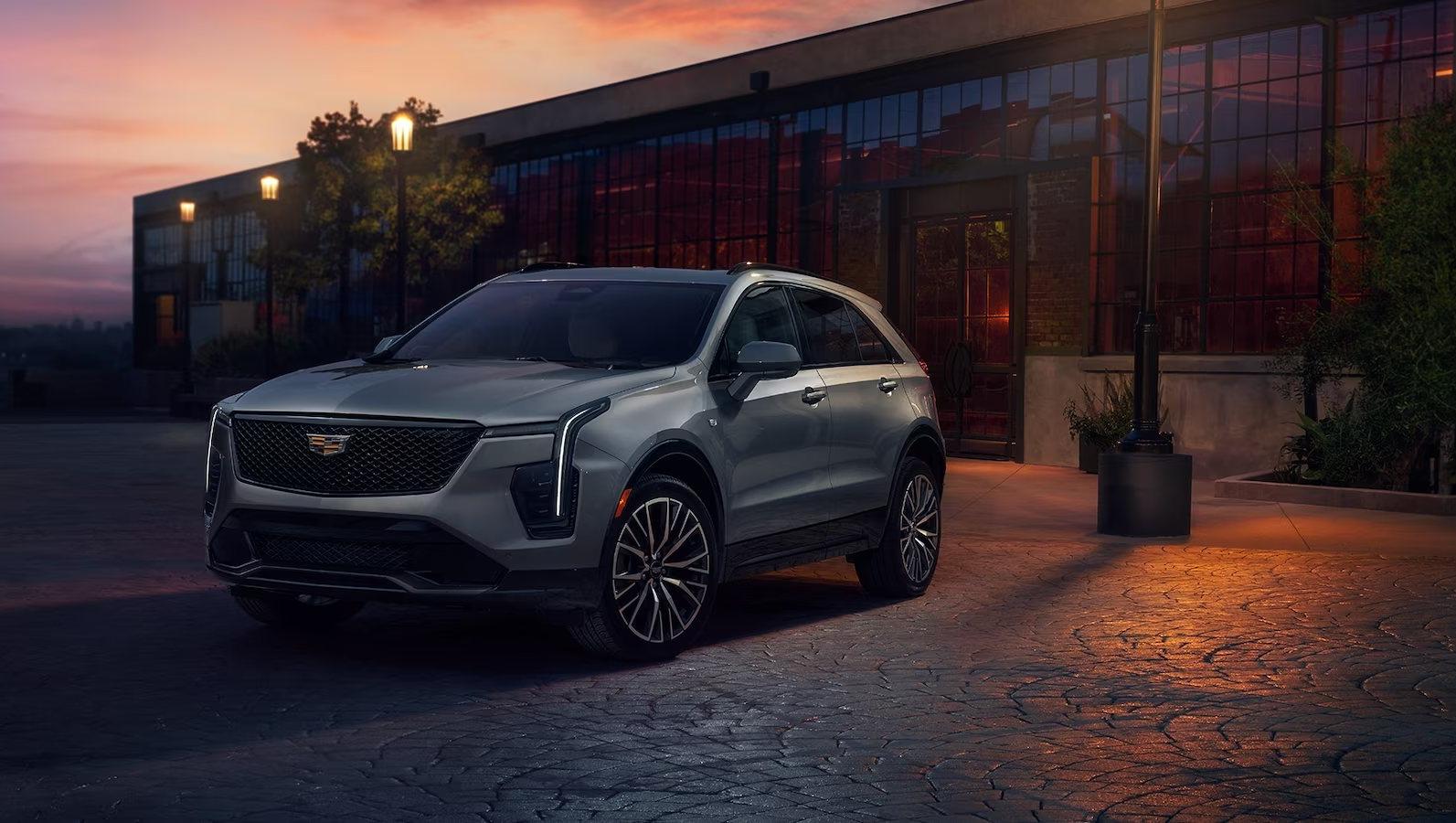 Silver 2024 Cadillac XT4 parked in front of a building in the evening