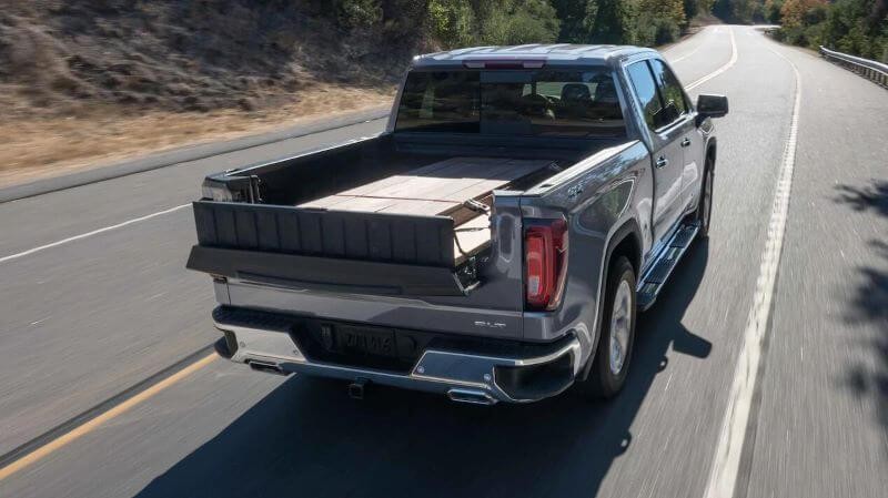 GMC Sierra 1500 hauling cargo on a road