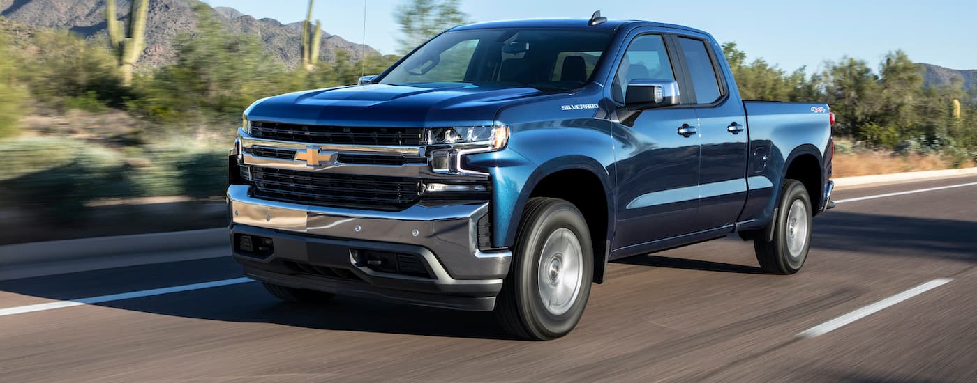 A popular vehicle for New Jersey car sales, a dark blue 2019 Chevy Silverado 1500 turbo, is shown driving down an empty highway.