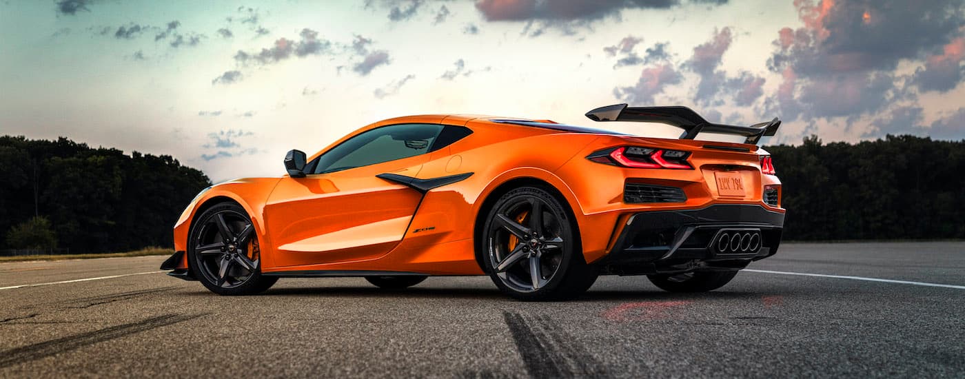 An orange 2023 Chevy Corvette Z06 is shown from the side on a cloudy day after visiting a Staten Island Chevy dealer.