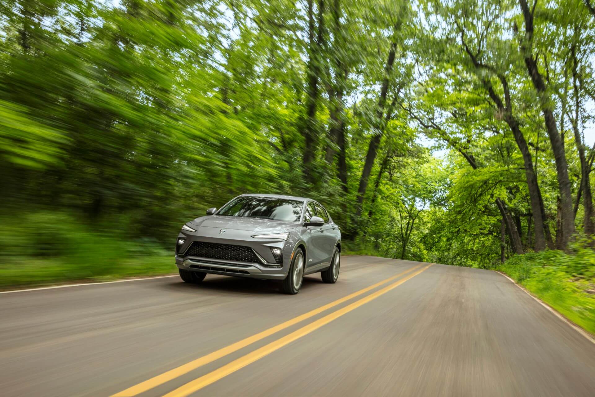 A 2024 Buick Envista SUV drives down a back road.