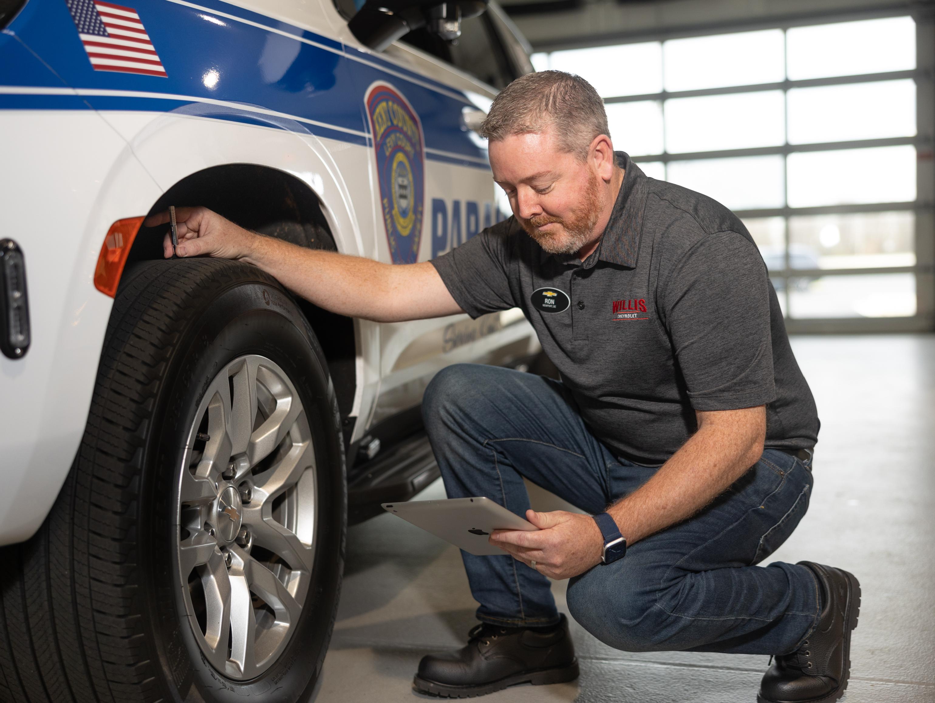 Chevrolet Service technician checking on tires of SUV