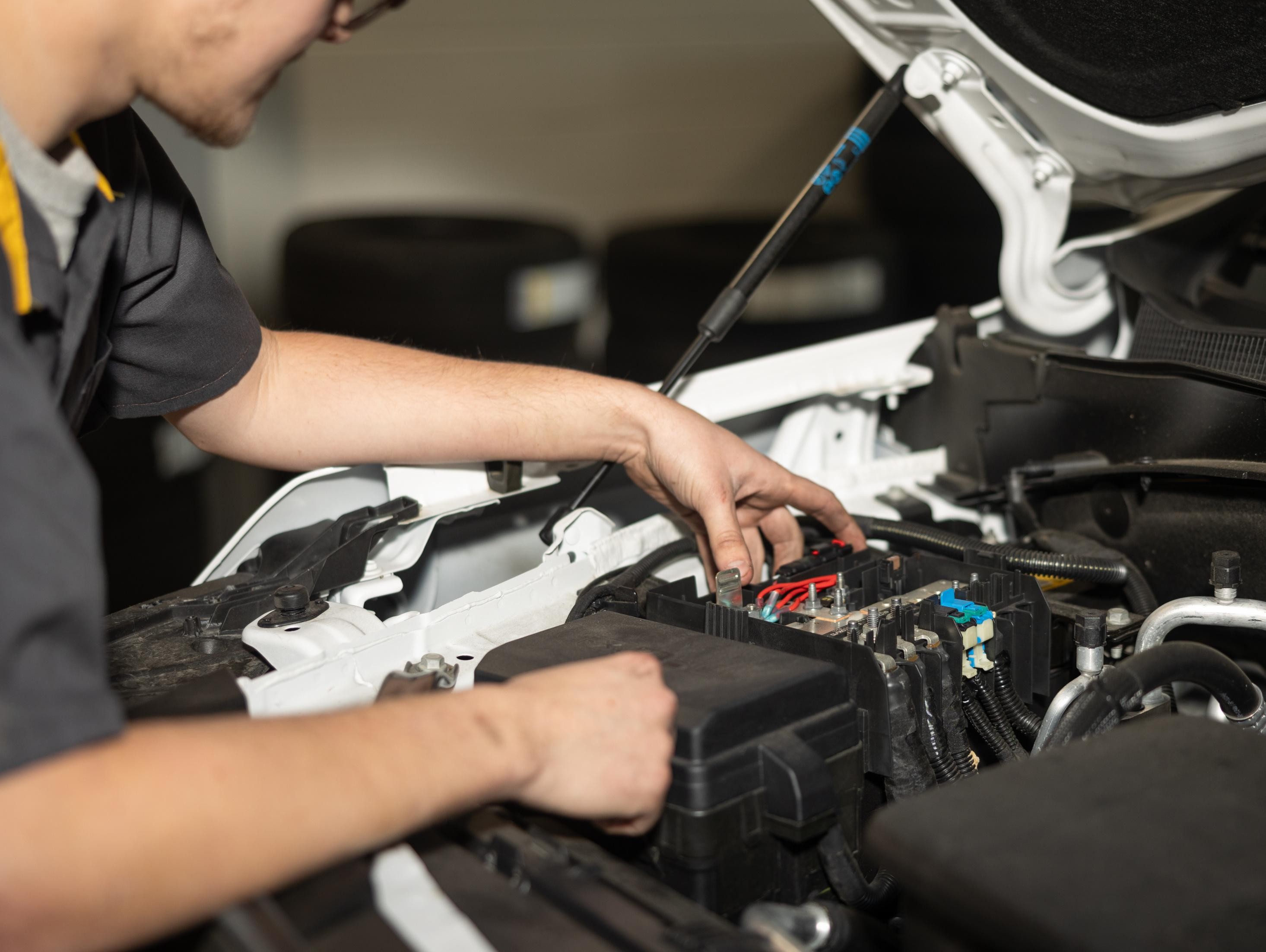 Service technician changing vehicle battery