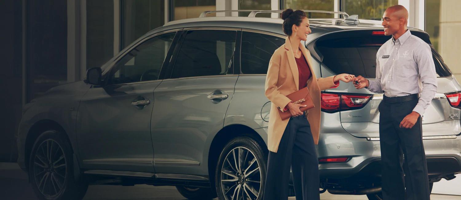 Lady shaking handing with advisor in dealership