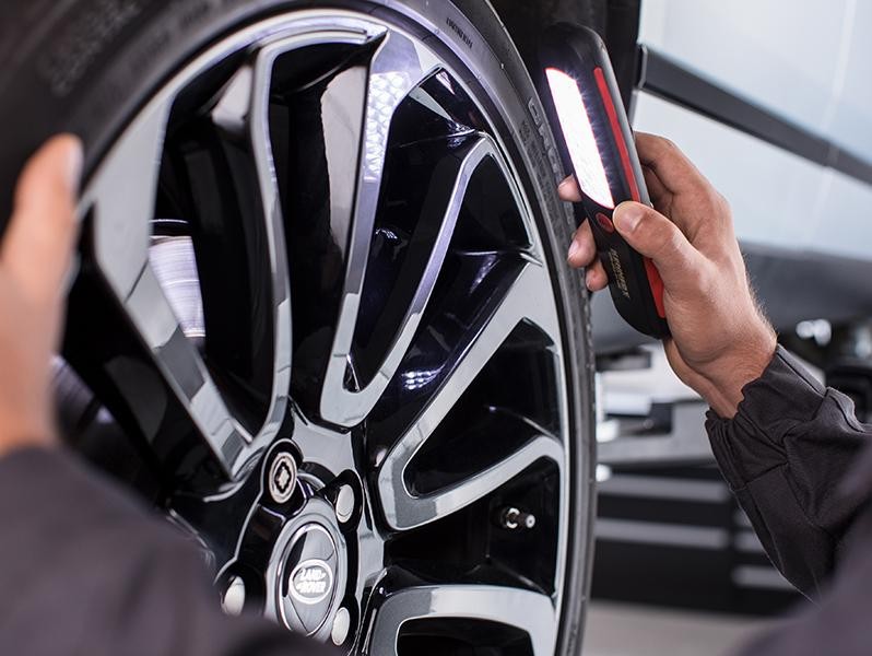 Factory-trained service technician inspecting the wheel and brakes.