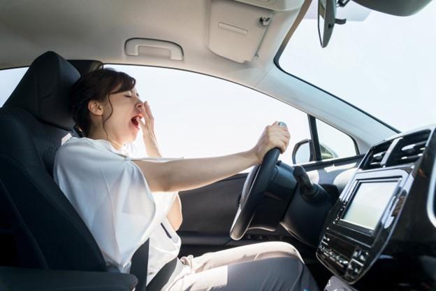 Woman yawning while driving the car