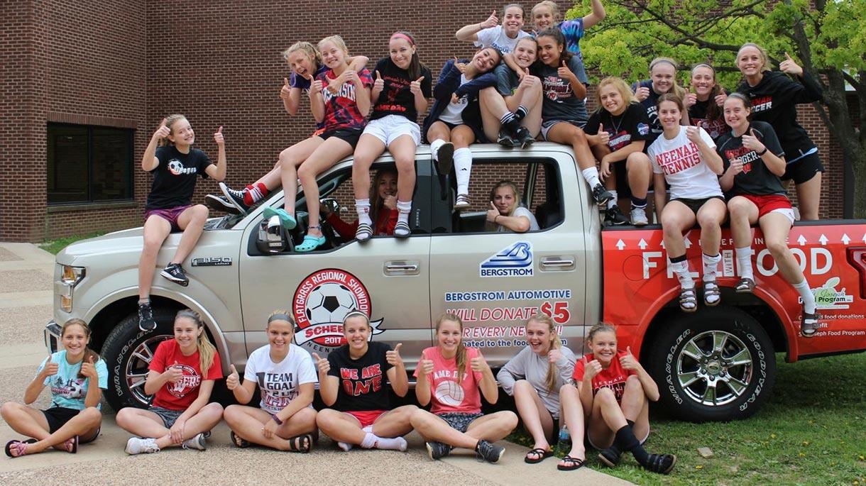 Group of girls smiling near a truck