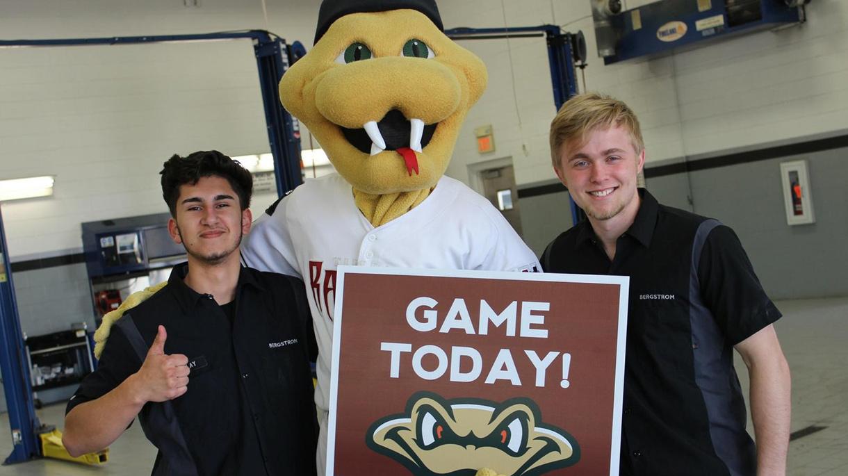 Two men smiling with the Wisconsin Timber Rattlers mascot, Fang