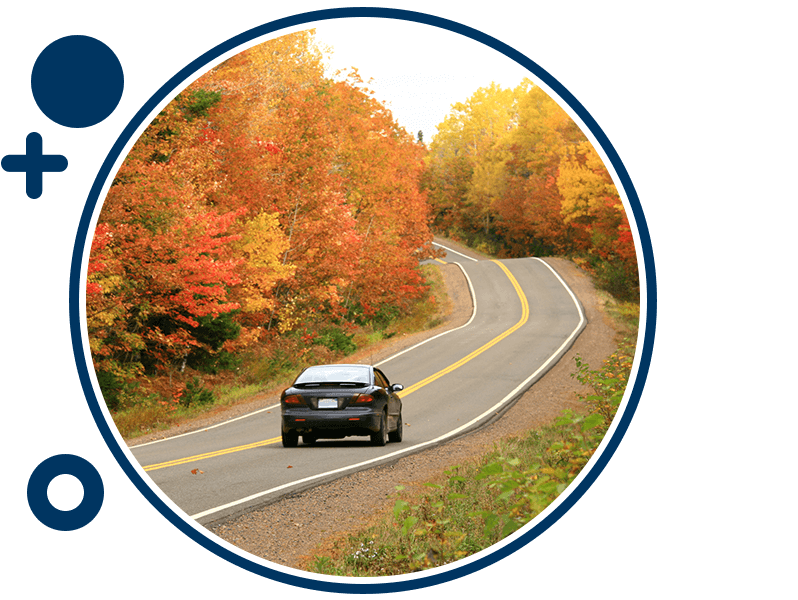 Car driving down a road during Fall