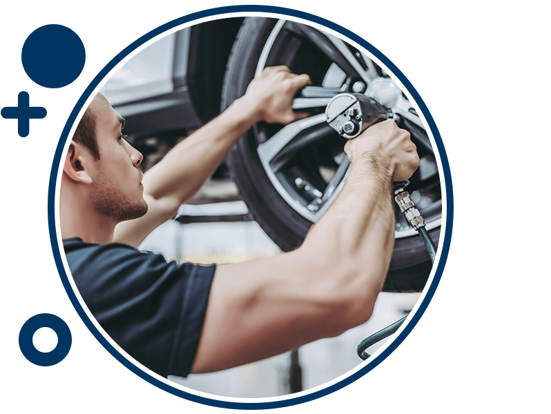 Service technician installing wheel on vehicle