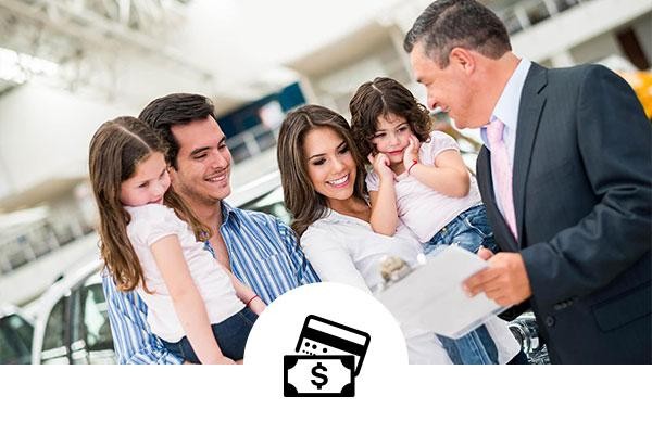 Family talking with a dealership sales associate with a dollar and credit card icon