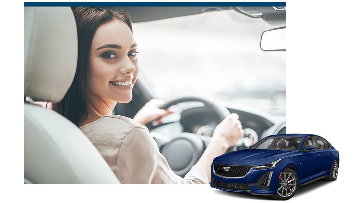 Blue Cadillac CT5 with a smiling woman in the driver's seat of a vehicle in the background