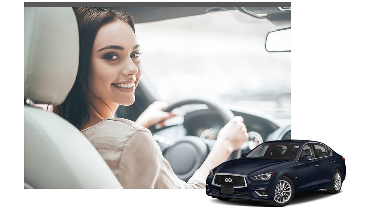 Blue INFINITI Q50 with a smiling woman in the driver's seat of a vehicle in the background