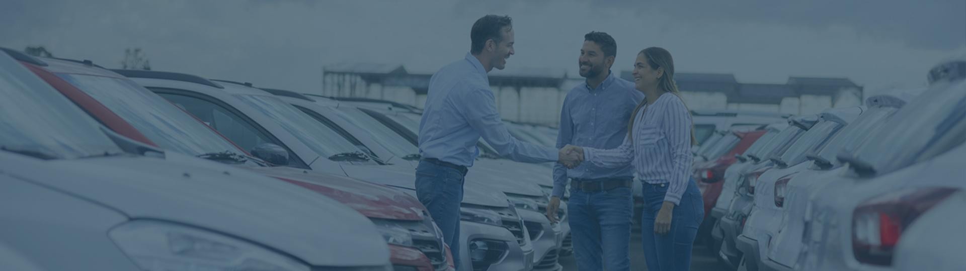 Woman shaking hands with customers in a dealership