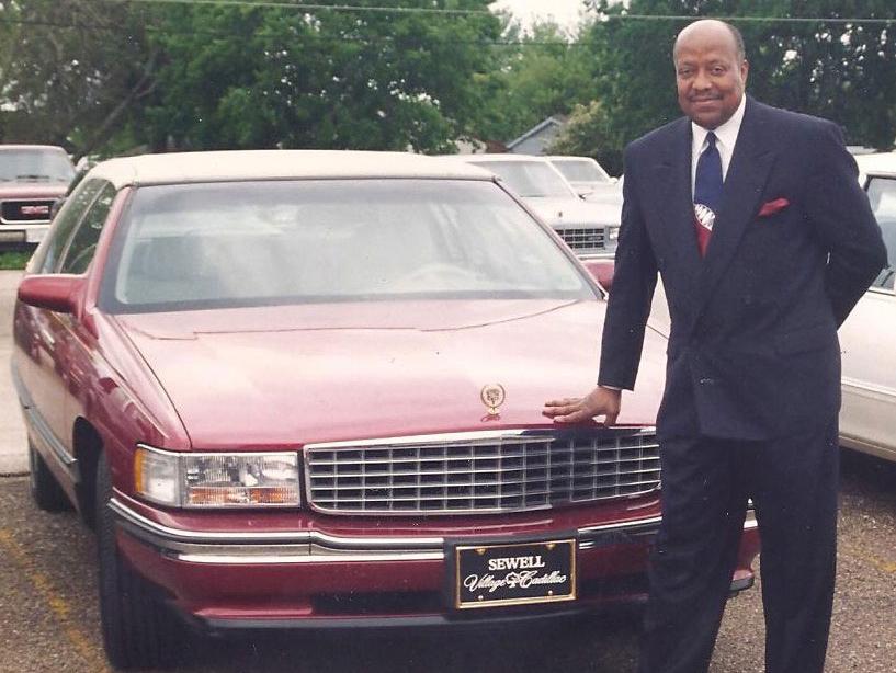 Joe Diggs standing with a Sewell Cadillac