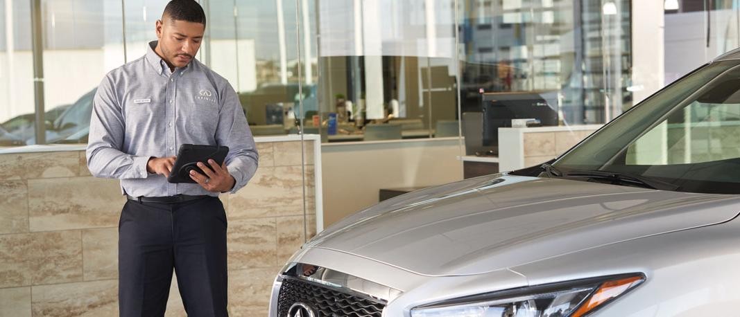 As we return to normal, our customers’ peace of mind is paramount.  Image of INFINITI technician making notes.