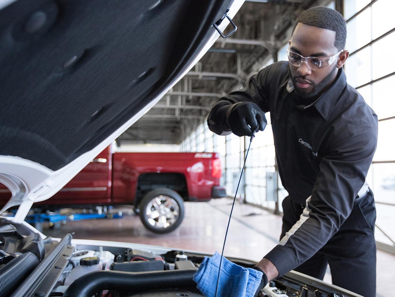 Service technician checking vehicle oil