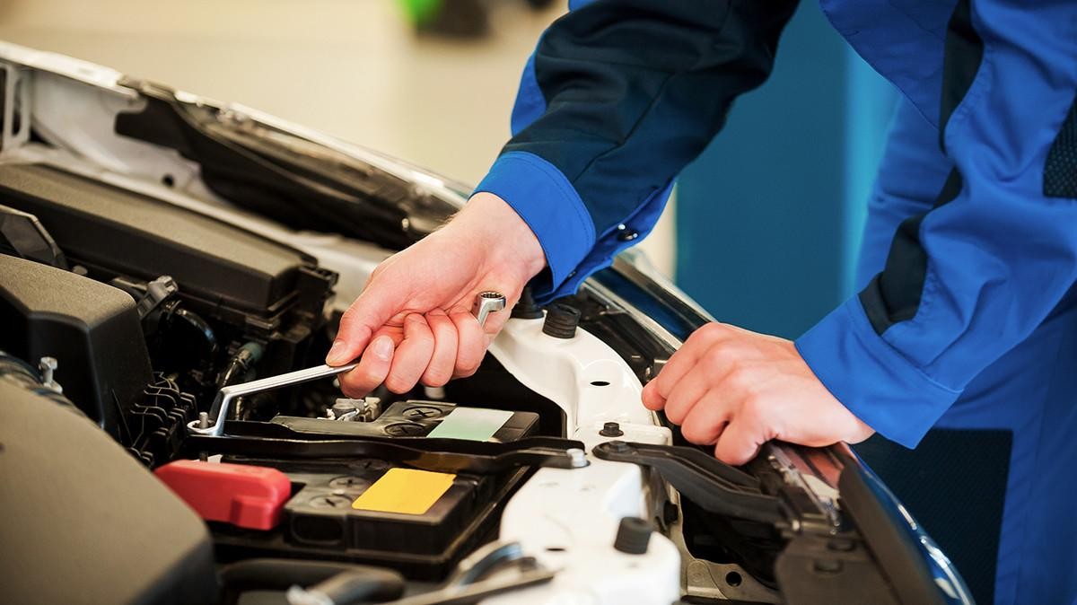 Hyundai service technician installing a battery on a vehicle.