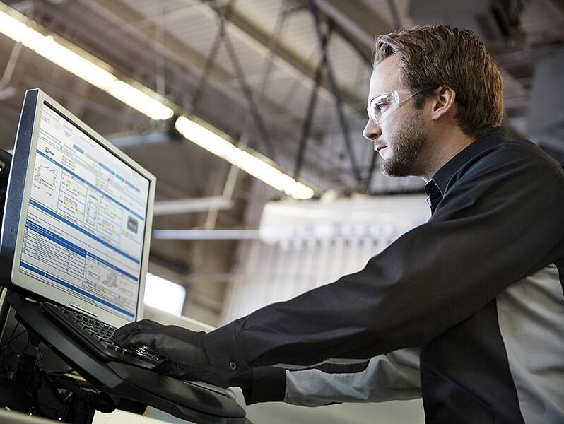 Certified Service Technician reviews computer diagnostics of a vehicle.