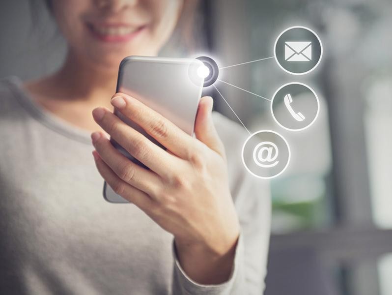 Woman holding cell phone, contact icons.