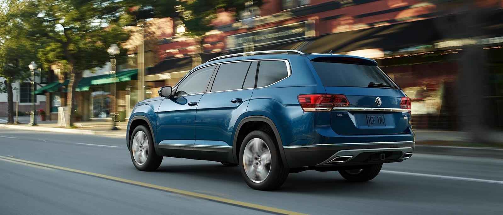 Blue 2018 VW Atlas driving down city street