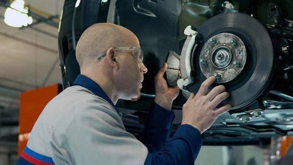 Ford Technician working on vehicle brakes