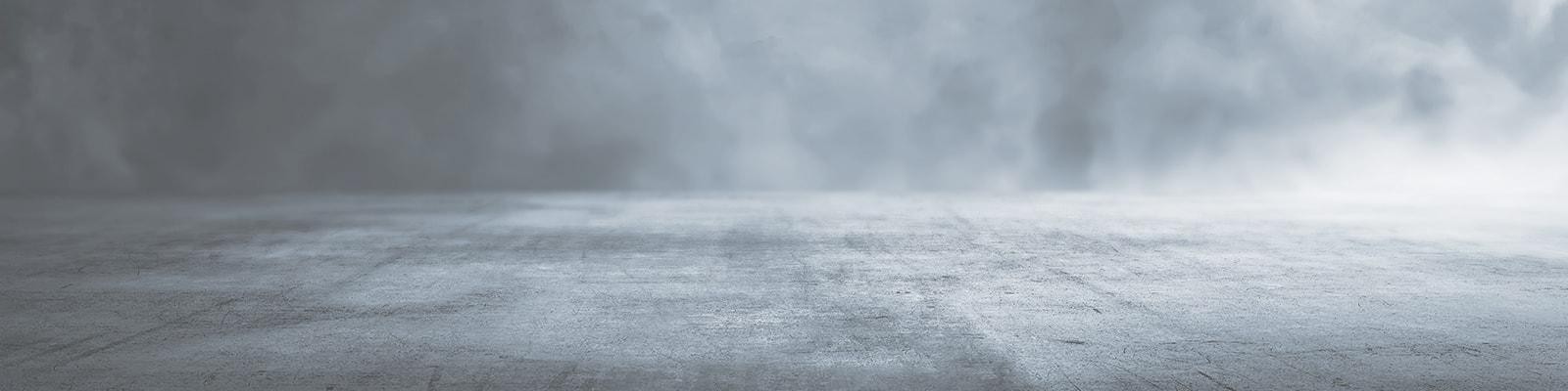 Hazy smoke rolling over a concrete floor