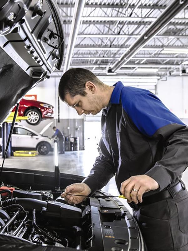 Ford Technician checking oil on vehicle