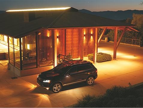 Black VW Toureg parked in driveway at night time. 