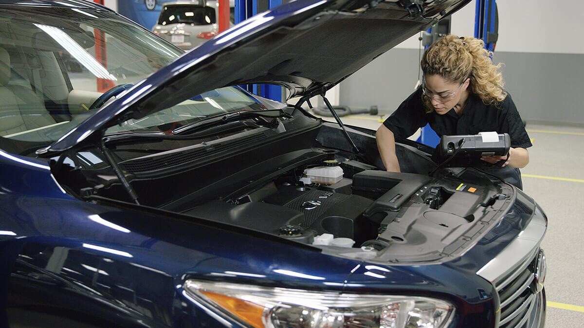 Infiniti technician performing diagnostics on vehicle.