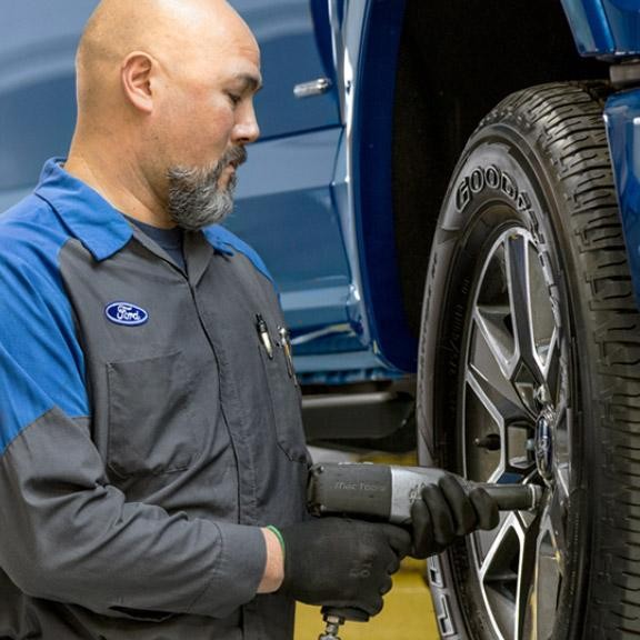 Ford Tire Tech putting tire on vehicle