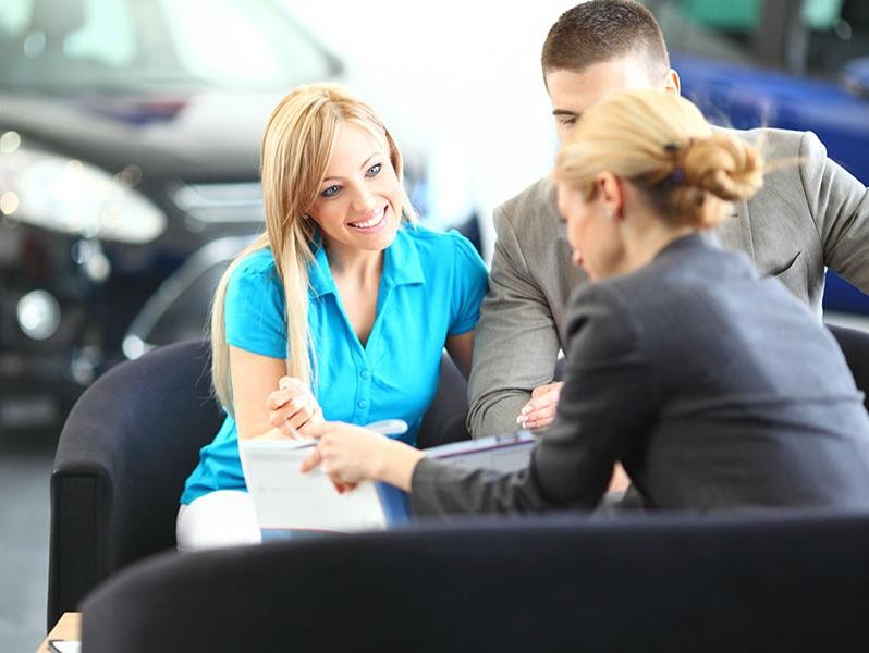 Woman at a customer service desk helping the customers with a transaction.