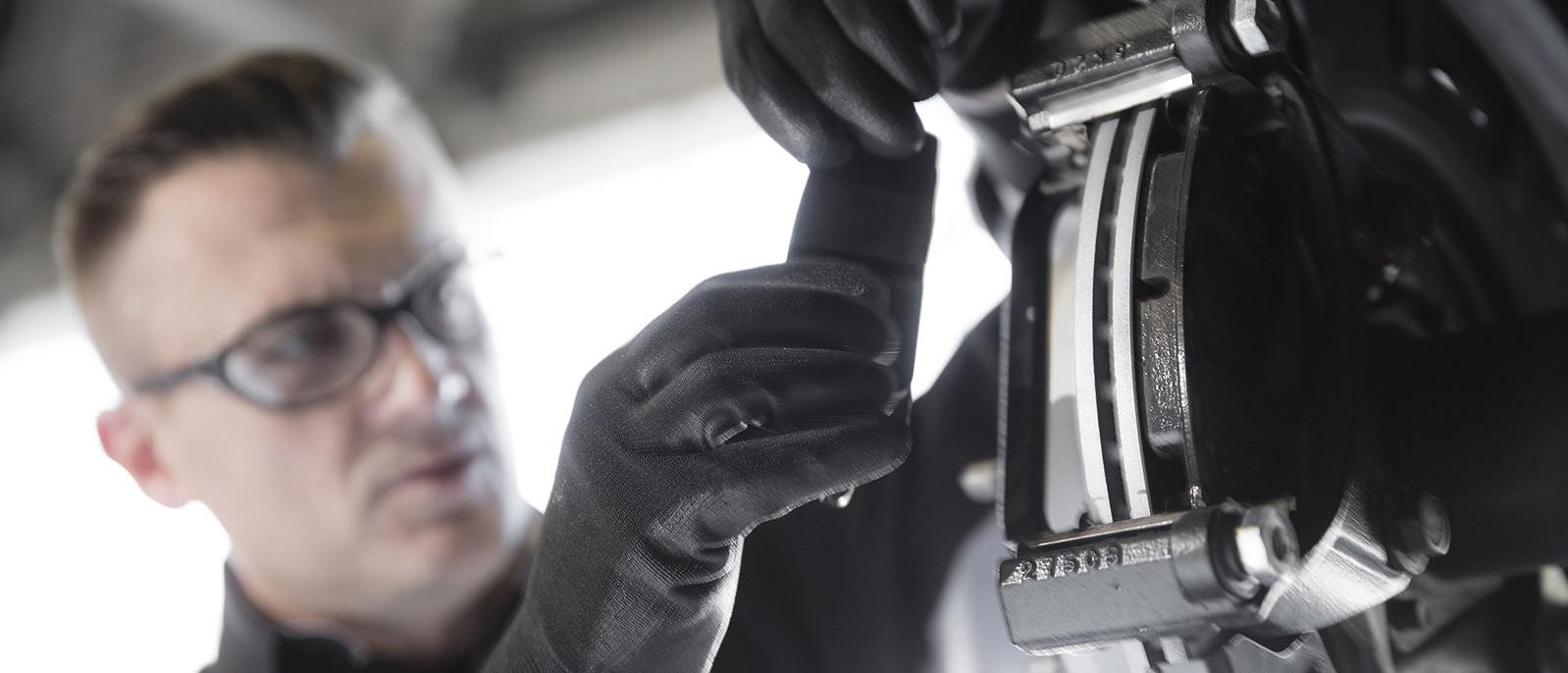 A service technician working on a vehicle's brakes.