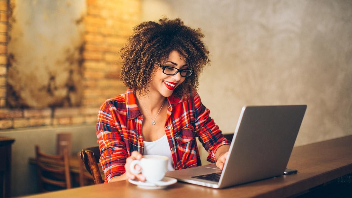 Woman at a cafe looking at her laptop computer.