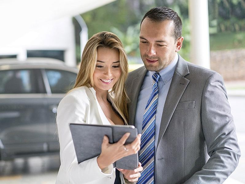 Salesman showing a customer information on a tablet.