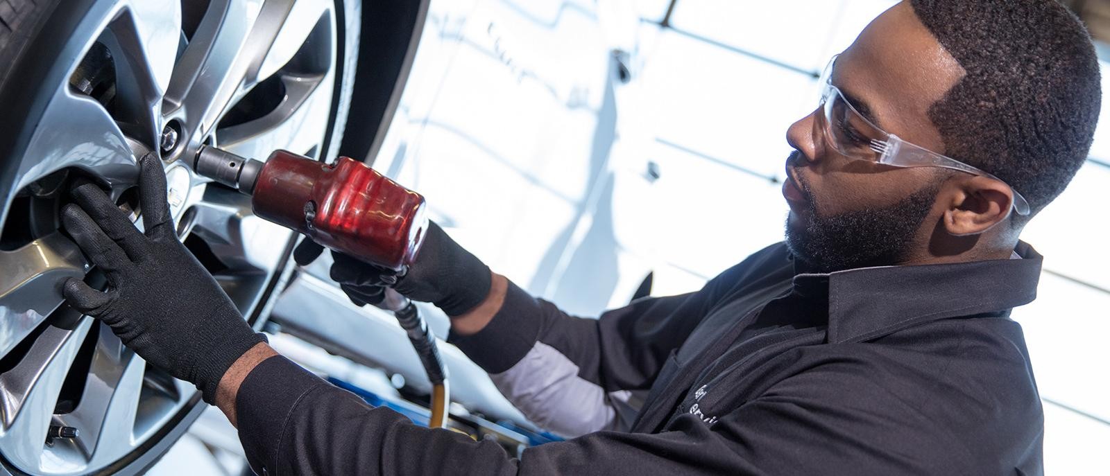 Certified service technician installing a tire