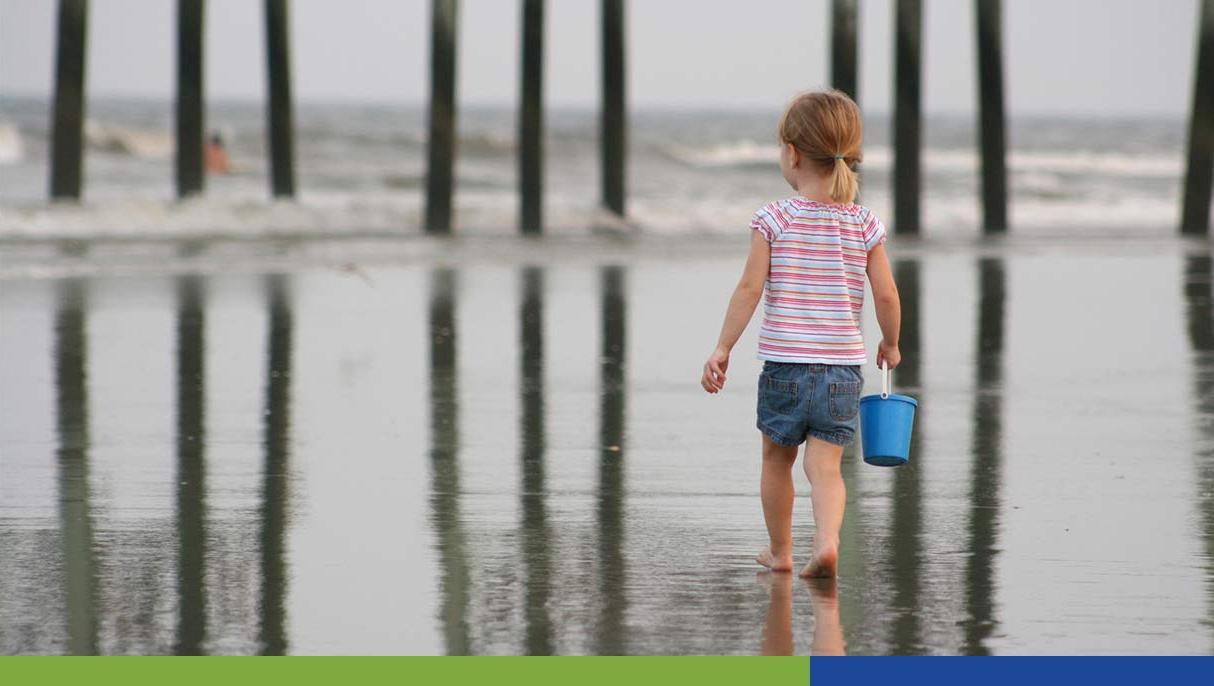 Royalty-Free photo: Child walking on shore holding scoop net